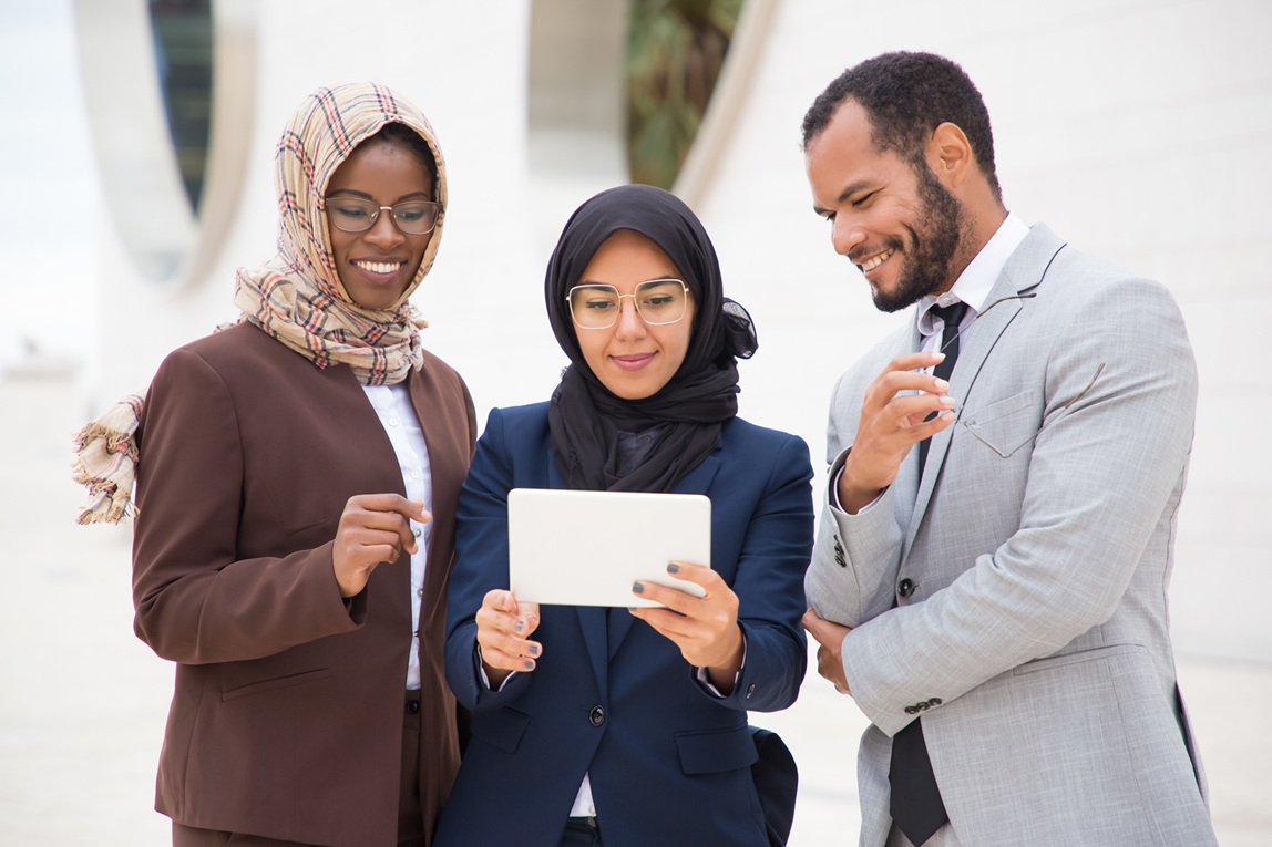 smiling managers using tablet outdoors