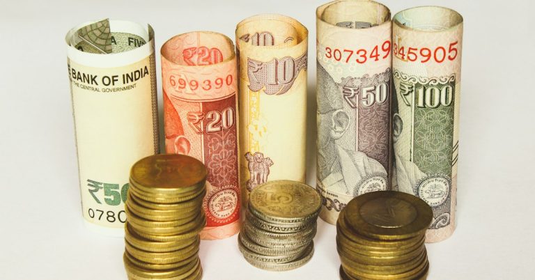 Indian rupee banknotes and coins representing types of employee compensation